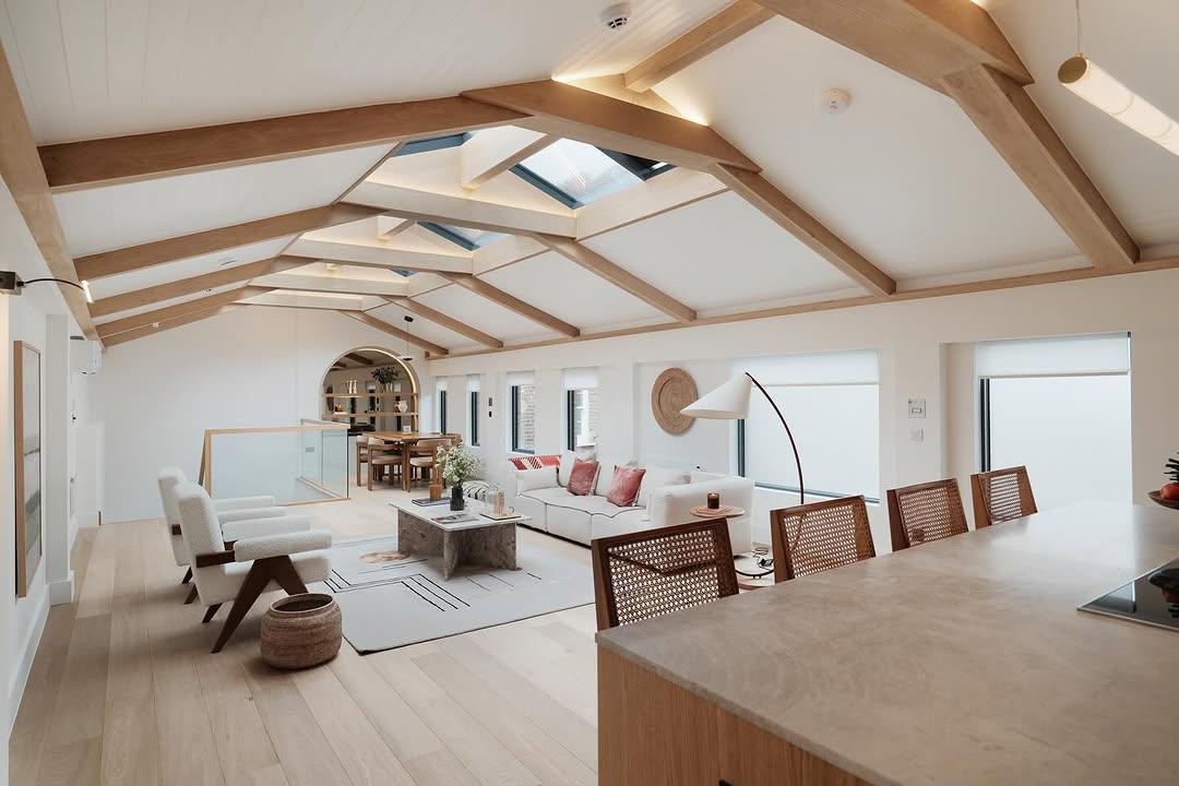 Open-plan loft living room with vaulted oak beam ceiling and skylights